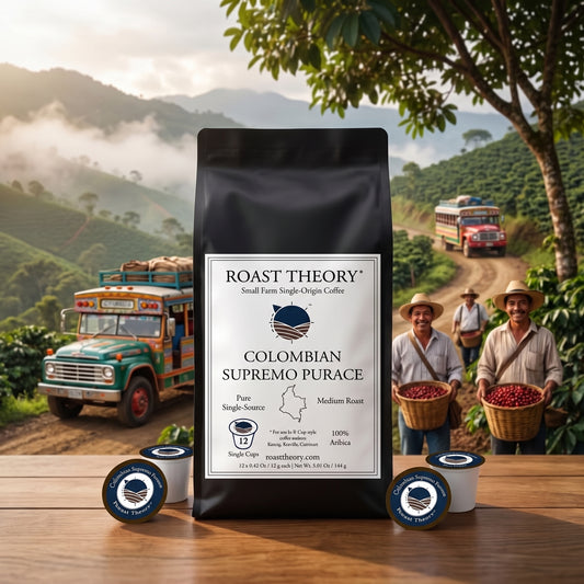 Colombian Supremo 100% Purace Coffee Pods Single-serve by Roast Theory. A black bag of Roast Theory Colombian Supremo Purace coffee stands on a wooden table, surrounded by two single-serve coffee pods and two round blue-and-white capsules. The background shows a scenic coffee plantation with workers carrying red coffee cherries, mountains, and vintage trucks.