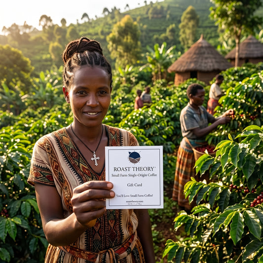 A woman in a coffee farm stands smiling and holding a gift card that reads 'ROAST THEORY Small Farm Single-Origin Coffee Gift Card' in front of a lush green coffee plantation with other workers and thatched huts in the background.