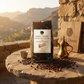 Yemen Harazi Mocha Jibal Raymah Coffee by Roast Theory with beans and a cup on a stone surface with a scenic background